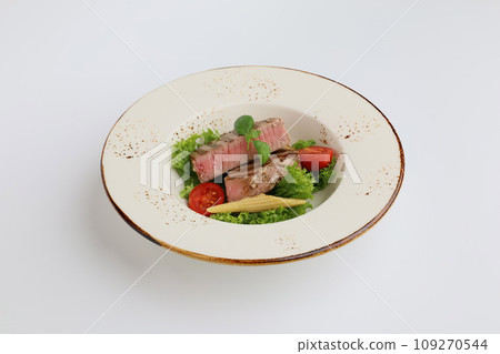 Tuna steak, lettuce and vegetables in a beautiful plate on a white background, restaurant serving 109270544