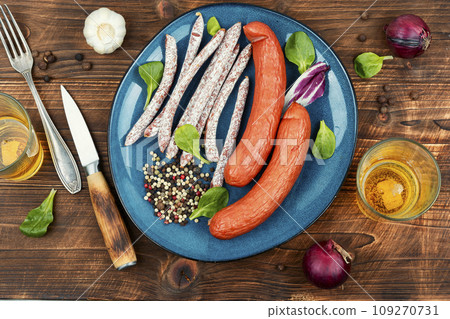 Thin kabanos sausages on wooden background. 109270731