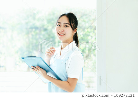 站在窗邊的年輕女性護理人員 109272121