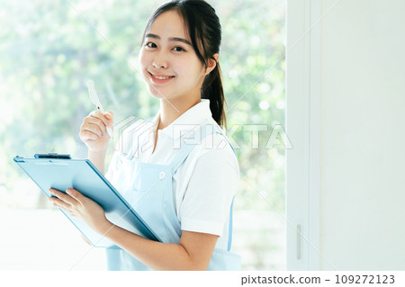 站在窗邊的年輕女性護理人員 109272123