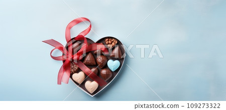 Valentines day chocolate candy sweets in heart shaped box on blue background. Traditional gift for birthday or Valentine's day. Close up. 14 February. Valentines day chocolate candy sweets in heart shaped box on blue background. Traditional gift for birthday or Valentine's day. Close up. 14 February. 109273322