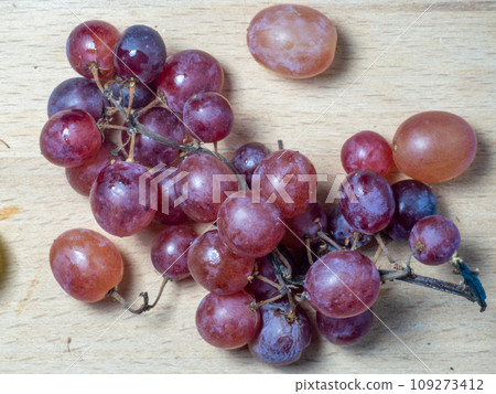 Red variety of grapes on the table. Berry harvest. Home furnishings. Kishmish on the table. Grapes of different colors. Fruit dessert. Wine ingredient. Red variety of grapes on the table. Berry harvest. Home furnishings. Kishmish on the table. Grapes of different colors. Fruit dessert. Wine ingredient. 109273412
