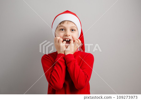 Cheerful boy in Santa hat on isolated gray background showing different funny emotions, surprise, joy, delight. Cheerful boy in Santa hat on isolated gray background showing different funny emotions, surprise, joy, delight. 109273973
