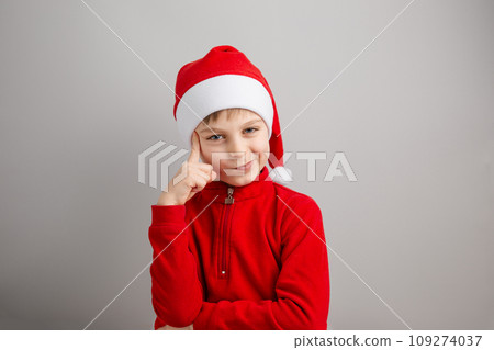 Cheerful boy in Santa hat on isolated gray background showing different funny emotions, surprise, joy, delight. 109274037