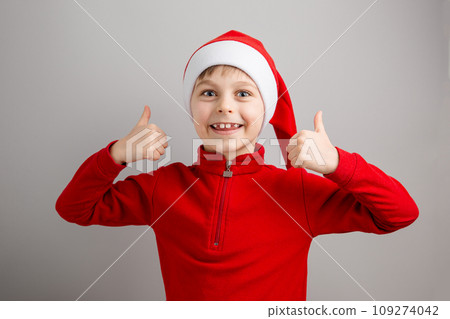 Cheerful boy in Santa hat on isolated gray background showing different funny emotions, surprise, joy, delight. 109274042