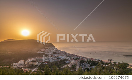 Aerial sunrise view of the coastline of the village of Sesimbra timelapse. Portugal Aerial sunrise view of the coastline of the village of Sesimbra timelapse. Portugal 109274075