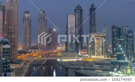 Cityscape with skyscrapers of Dubai Business Bay and water canal aerial night to day timelapse. 109274095