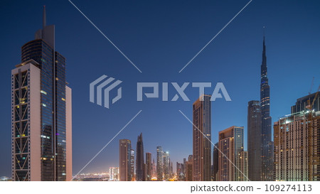 Aerial sunrise view of Dubai Downtown skyline with many towers night to day timelapse. 109274113