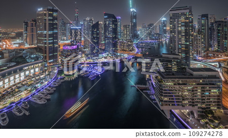 Aerial view to Dubai marina skyscrapers around canal with floating boats night timelapse Aerial view to Dubai marina skyscrapers around canal with floating boats night timelapse 109274278
