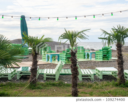 The interior of a street restaurant among palm trees. Cafe in green colors. Vacation at the resort. The interior of a street restaurant among palm trees. Cafe in green colors. Vacation at the resort. 109274400