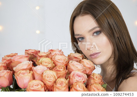 Beautiful face of the model and with a bouquet of roses. Woman with flowers. Beautiful face of the model and with a bouquet of roses. Woman with flowers. 109274453