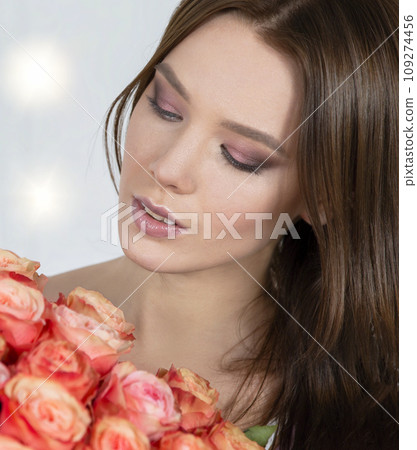 Beautiful face of the model and with a bouquet of roses. Woman with flowers. Beautiful face of the model and with a bouquet of roses. Woman with flowers. 109274456