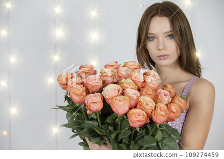 Portrait of a young beautiful girl with a bouquet of roses 109274459