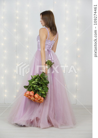 Vertical beautiful girl with a bouquet of roses in full growth 109274461