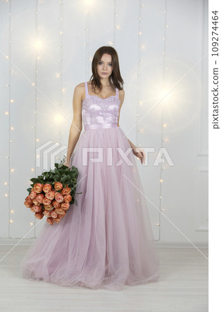 Vertical beautiful girl with a bouquet of roses in full growth 109274464