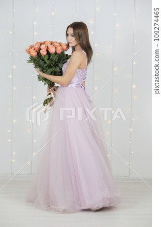 Vertical beautiful girl with a bouquet of roses in full growth 109274465