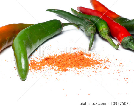 The green pepper and ground red pepper are isolated. Spicy pepper on a white background. Ingredient for a burning dish. 109275073