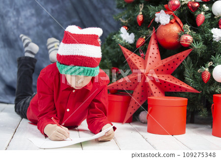 Child at Christmas. Boy child writes a letter to Santa Claus. 109275348