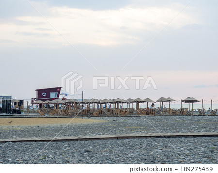 Bar by the sea. Resort place. Umbrellas and sunbeds on the beach. Beach at sunset. Beach business. 109275439