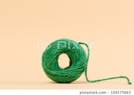 Skein of green thread on a beige background 109275663