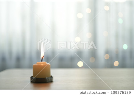 Candle on table with bokeh light and curtain 109276189