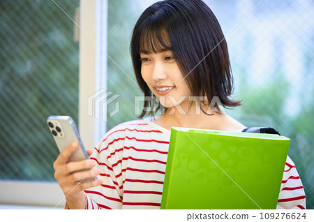 Female college student looking at smartphone Photography cooperation: Ariake College of Education and Arts Female college student looking at smartphone Photography cooperation: Ariake College of Education and Arts 109276624