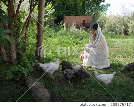 Girl feeding chickens in the garden 109276717