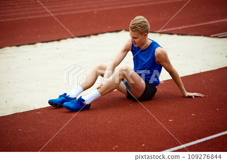 Athlete's journey to excellence begins with a focused warm-up. Full length portrait of man warming-up on sport court before championship Athlete's journey to excellence begins with a focused warm-up. Full length portrait of man warming-up on sport court before championship 109276844