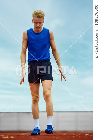 Focused runner propelling forward with intent. Young athlete man, professional sportsman warming-up before championship. Focused runner propelling forward with intent. Young athlete man, professional sportsman warming-up before championship. 109276900
