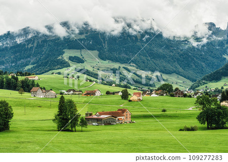 Small village on green hill among Swiss Alps in summer at Switzerland Small village on green hill among Swiss Alps in summer at Switzerland 109277283