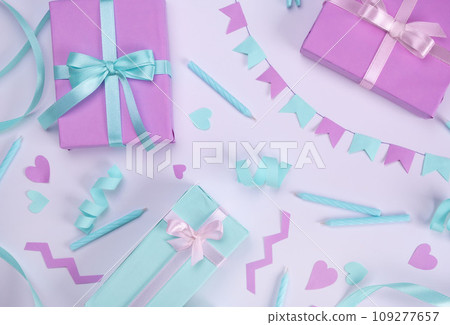 white background with candles, gift boxes, serpentine and holiday decorations in blue and lilac colors for birthday or party celebration, birthday, anniversary, congratulations concept.  109277657