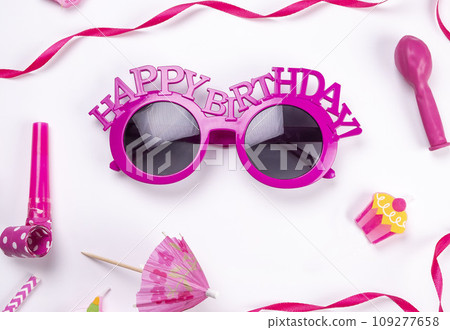 white background with glasses, balloons and tubes for birthday or party celebration, birthday, anniversary concept in pink colors or for a girl, congratulations.  109277658