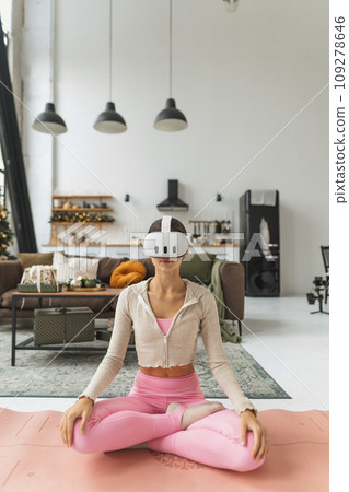 A modern young lady embraces the holiday mood while wearing a virtual reality headset. A modern young lady embraces the holiday mood while wearing a virtual reality headset. 109278646