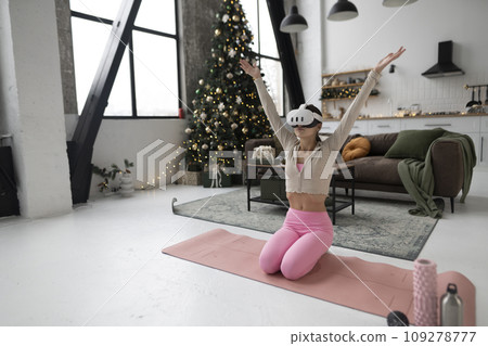 A yoga instructor leads online training sessions with a virtual reality headset during the holiday season. A yoga instructor leads online training sessions with a virtual reality headset during the holiday season. 109278777