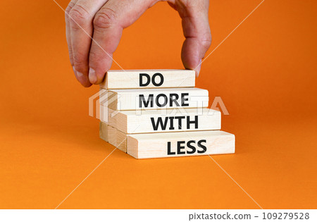 Do more with less symbol. Concept word Do more with less on beautiful wooden block. Beautiful orange table orange background. Businessman hand. Business do more with less concept. Copy space. 109279528
