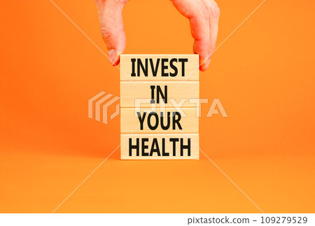 Invest in your health symbol. Concept word Invest in your health on beautiful wooden block. Beautiful orange table orange background. Doctor hand. Invest in your health concept. Copy space. 109279529