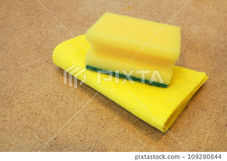 Napkin and washcloth for washing dishes on a brown wooden background. Napkin and washcloth for washing dishes on a brown wooden background. 109280844