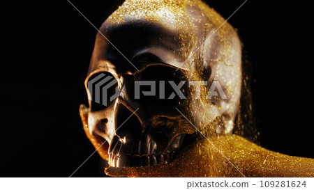 Hand with human skull on black. Golden sands, time concept. Symbolism, mortality Hand with human skull on black. Golden sands, time concept. Symbolism, mortality 109281624