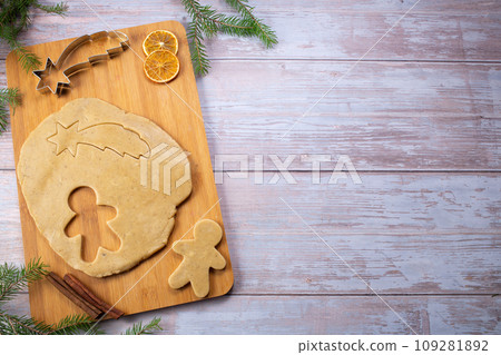 Christmas baking. Ginger dough for gingerbread, gingerbread men, star, Christmas trees, spices. Flat lay.Copy space 109281892