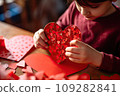 Kid making heart-shaped Valentine's card 109282841