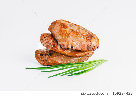 Chicken wings fried until half cooked, semi-finished product with fresh herbs on a white background. Fast food. Quick cooking at home. Copy space.Fast cooking.Fast homemade food. 109284422