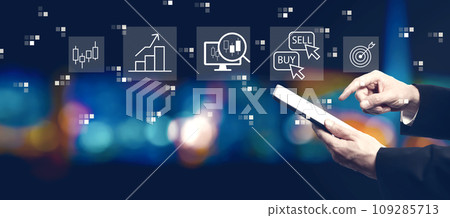 Stock trading theme with businessman using a tablet computer Stock trading theme with businessman using a tablet computer 109285713
