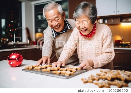 Happy elderly Asian couple cooks delicious gingerbread men for Christmas holiday at home 109286990