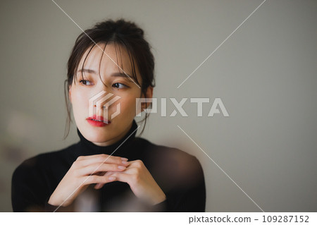 一位身穿黑色針織衫的女士將下巴靠在背上 109287152