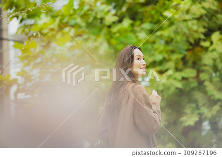 A woman in a coat walking outdoors A woman in a coat walking outdoors 109287196