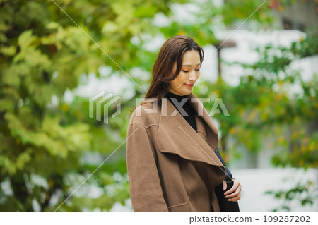穿著外套在戶外散步的女人 109287202