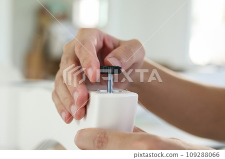 Asian man assembling furniture at home with adjustable table leg Asian man assembling furniture at home with adjustable table leg 109288066