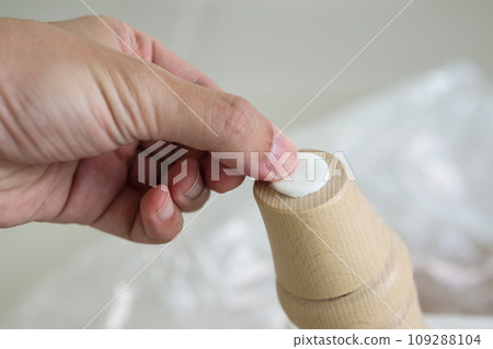 Man sticking floor care pad at sofa leg 109288104