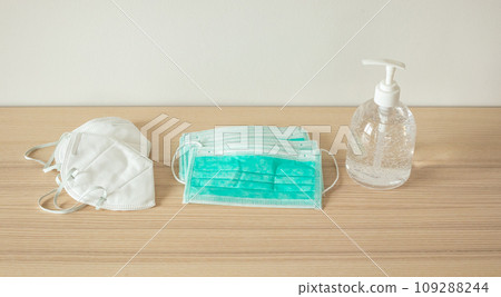 Medical face mask with alcohol sanitizer gel hand wash on wood table for covid-19 Coronavirus prevention concept 109288244