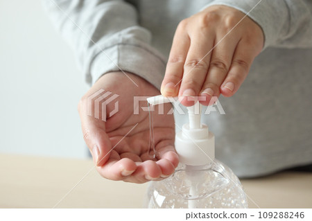 Woman using alcohol sanitizer gel rub for cleaning hand COVID-19 corona virus prevention concept 109288246